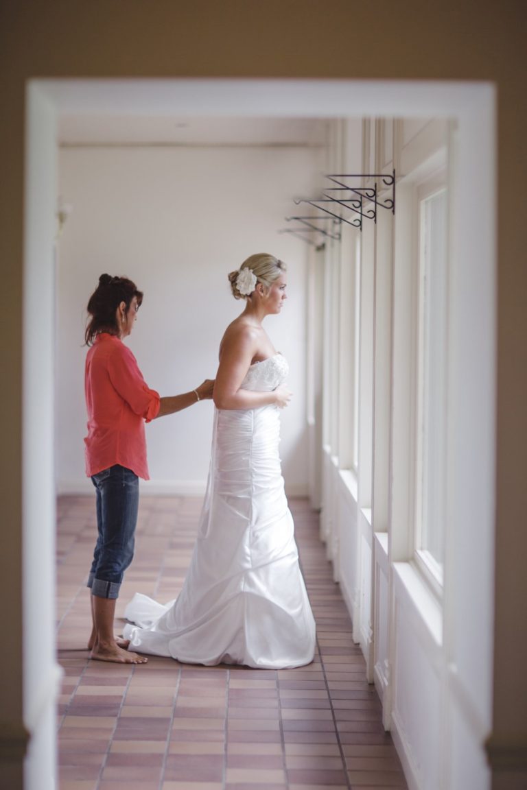 bride being zipped up in her dress